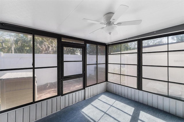 unfurnished sunroom featuring ceiling fan and a wealth of natural light