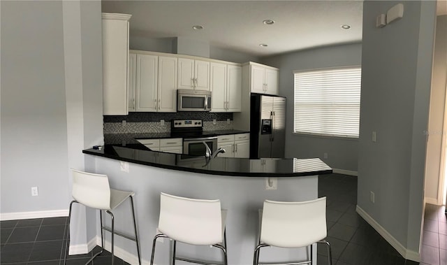 kitchen with stainless steel appliances, a kitchen bar, and kitchen peninsula