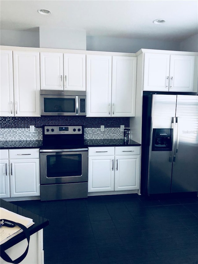 kitchen featuring backsplash, appliances with stainless steel finishes, and white cabinets