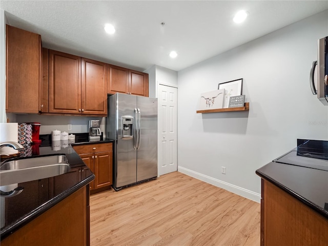 kitchen featuring light hardwood / wood-style flooring, sink, and stainless steel fridge