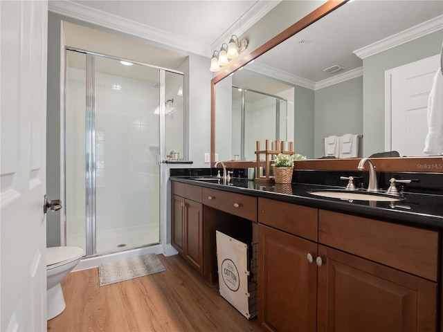 bathroom featuring toilet, a shower with shower door, ornamental molding, vanity, and hardwood / wood-style floors