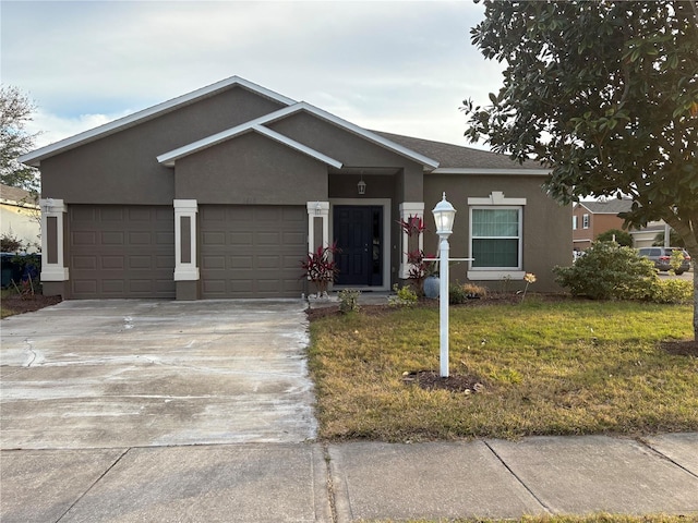 ranch-style house featuring a garage and a front lawn