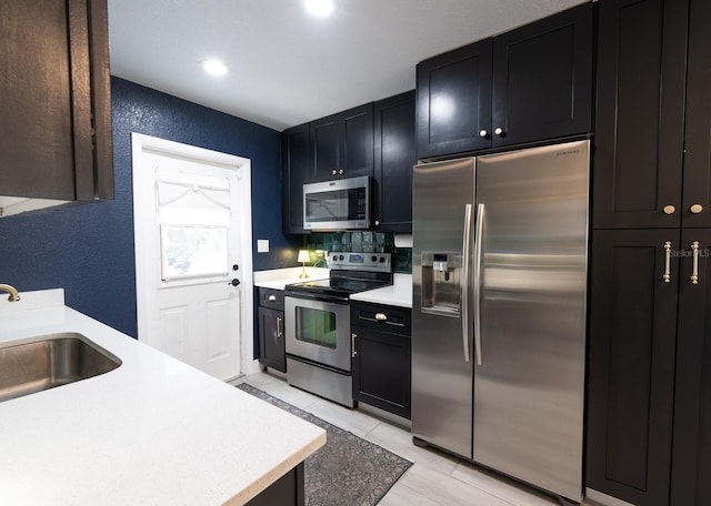 kitchen with tasteful backsplash, sink, and appliances with stainless steel finishes