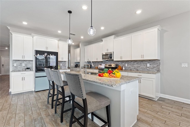 4608 Egg Harbor Dr, Kissimmee, FL 34746 - kitchen featuring white cabinetry, a center island with sink, and appliances with stainless steel finishes