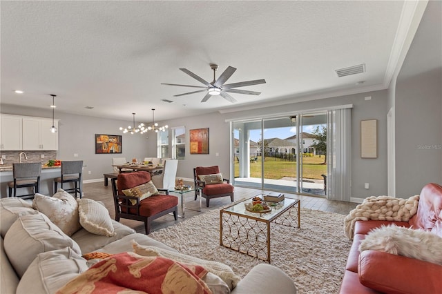 4608 Egg Harbor Dr, Kissimmee, FL 34746 - living room with ceiling fan with notable chandelier, a textured ceiling, and light hardwood / wood-style flooring