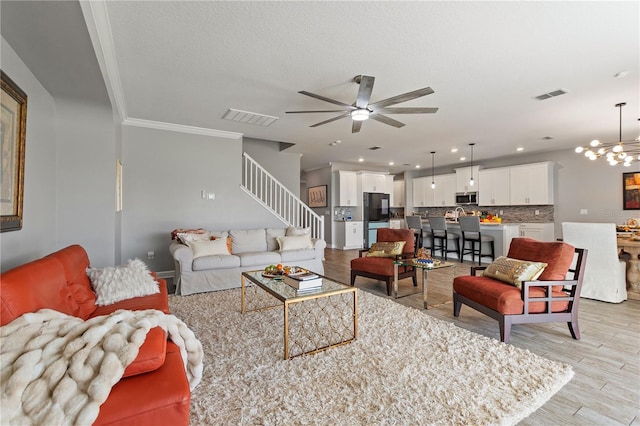 4608 Egg Harbor Dr, Kissimmee, FL 34746 - living room with crown molding, ceiling fan with notable chandelier, a textured ceiling, and light hardwood / wood-style floors