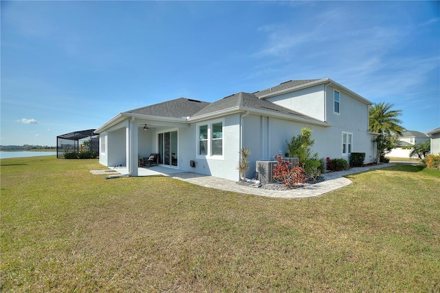 4608 Egg Harbor Dr, Kissimmee, FL 34746 - rear view of property with a patio area, central air condition unit, a water view, glass enclosure, and a lawn