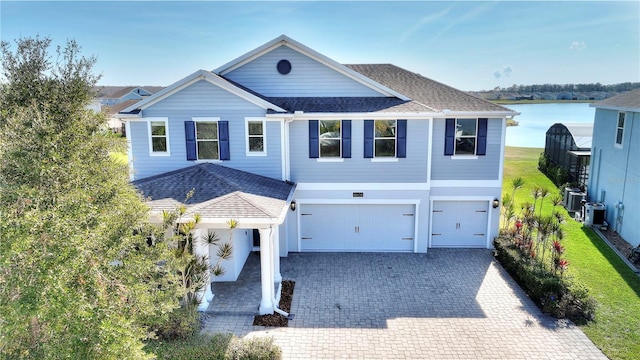 4608 Egg Harbor Dr, Kissimmee, FL 34746 - view of front facade with a water view, a garage, and central air condition unit