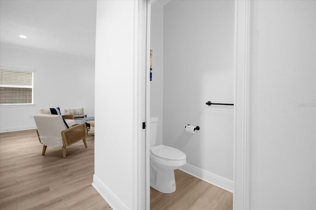 bathroom with hardwood / wood-style flooring and toilet