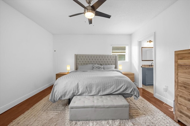 bedroom featuring connected bathroom, hardwood / wood-style flooring, and ceiling fan