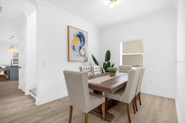 dining area featuring crown molding and light hardwood / wood-style flooring