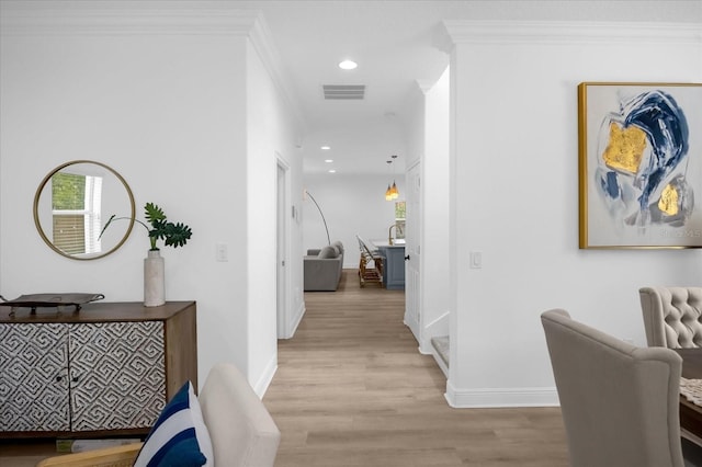 hallway with crown molding and light hardwood / wood-style flooring