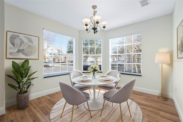 dining room featuring visible vents, baseboards, and wood finished floors