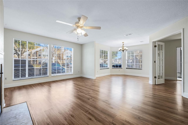 unfurnished living room featuring a healthy amount of sunlight, a textured ceiling, and wood finished floors