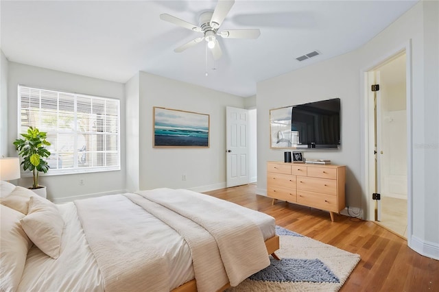 bedroom with a ceiling fan, baseboards, visible vents, and light wood finished floors