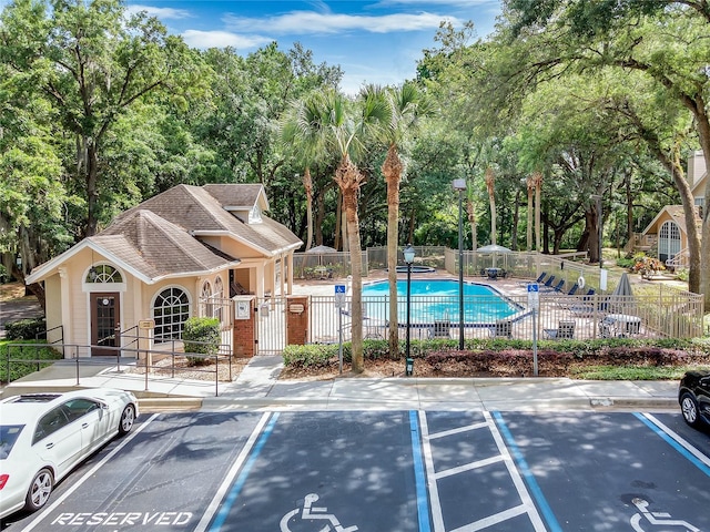 exterior space featuring fence and a community pool