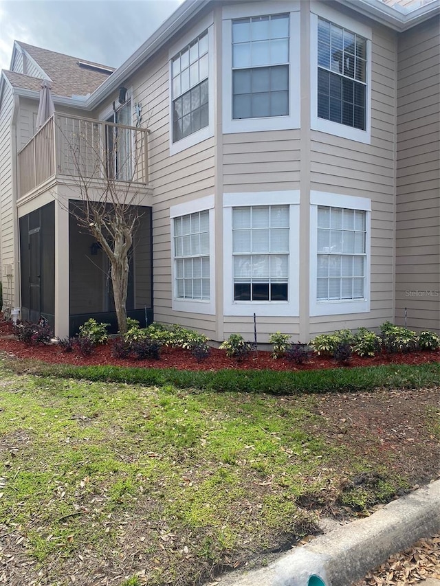 view of home's exterior featuring a yard and a balcony