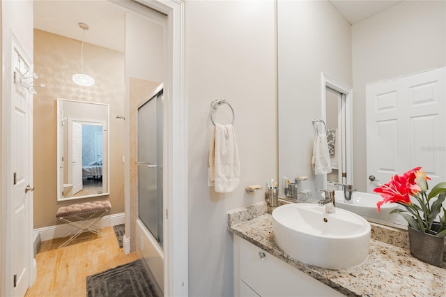 bathroom featuring vanity, combined bath / shower with glass door, and hardwood / wood-style floors