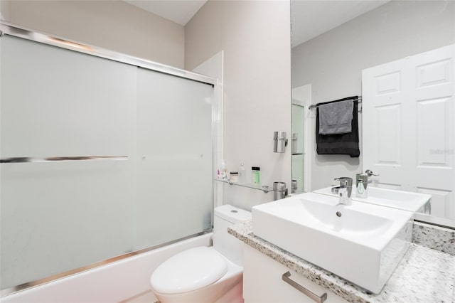 full bathroom with vanity, enclosed tub / shower combo, and toilet