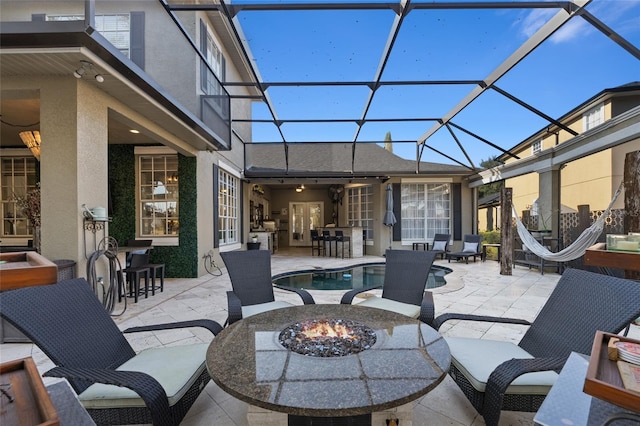 view of patio / terrace featuring an outdoor fire pit, exterior bar, and glass enclosure