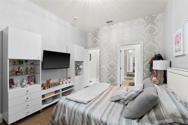 bedroom with dark hardwood / wood-style flooring and a textured ceiling