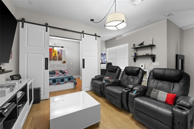 cinema room featuring a barn door and light wood-type flooring