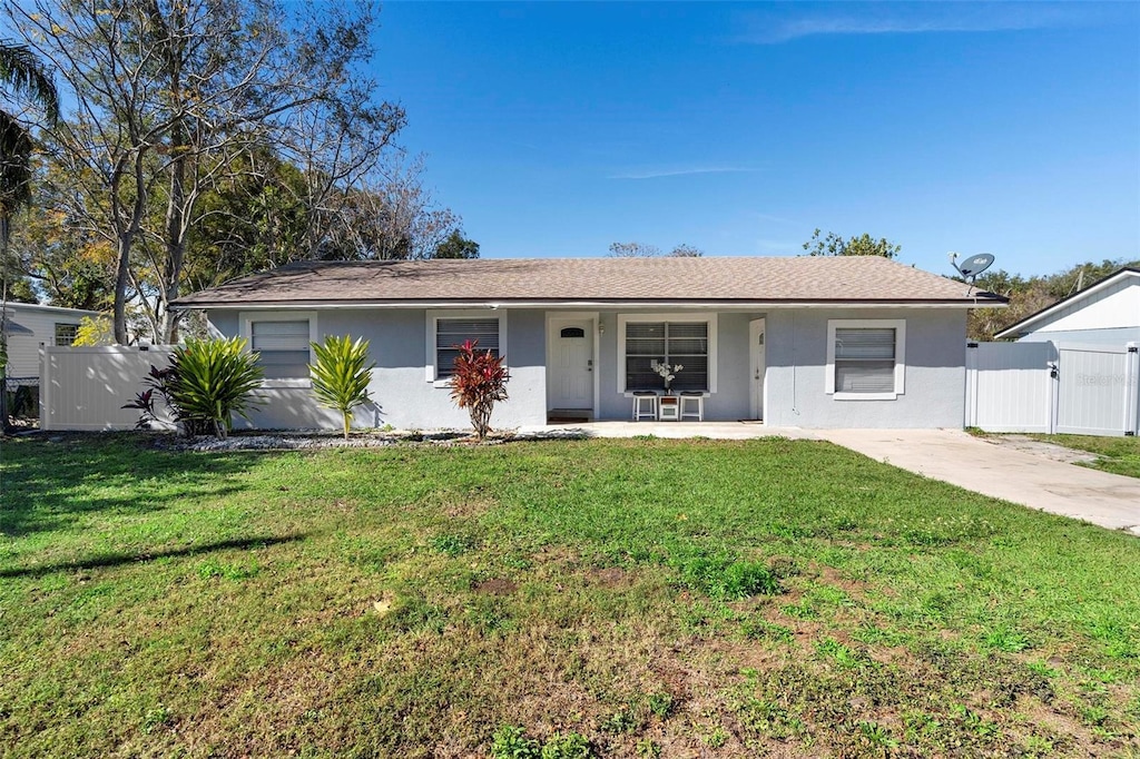 ranch-style house with a front yard and covered porch