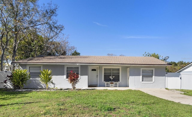 ranch-style home featuring a garage and a front lawn