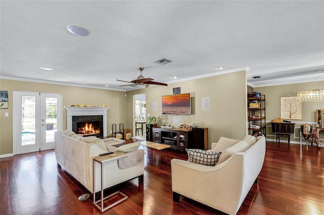 living room with french doors, a textured ceiling, ornamental molding, dark hardwood / wood-style flooring, and ceiling fan