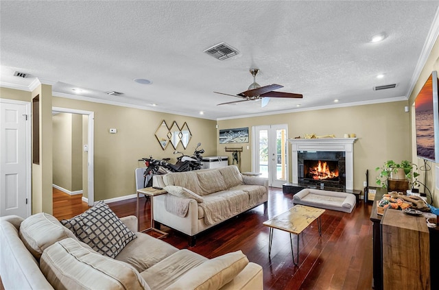 living room featuring french doors, crown molding, a textured ceiling, dark hardwood / wood-style floors, and a high end fireplace