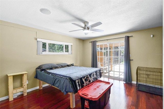 bedroom featuring multiple windows, dark wood-type flooring, access to outside, and a textured ceiling