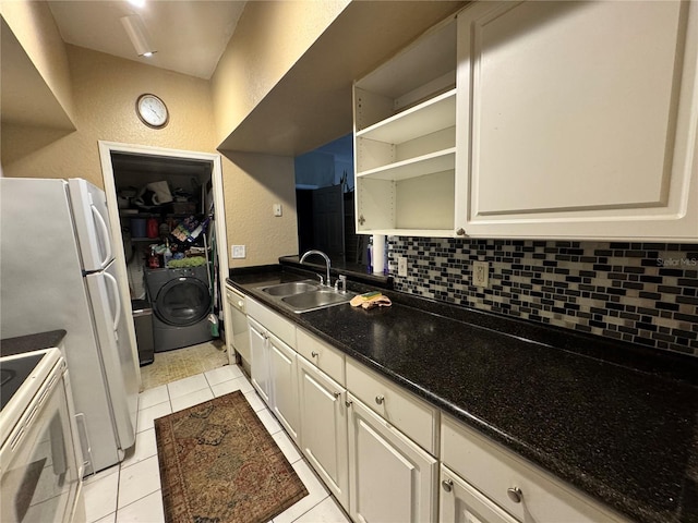 kitchen with sink, white appliances, light tile patterned floors, backsplash, and washer / dryer