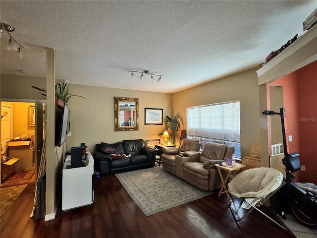 living room with dark hardwood / wood-style floors, track lighting, and a textured ceiling