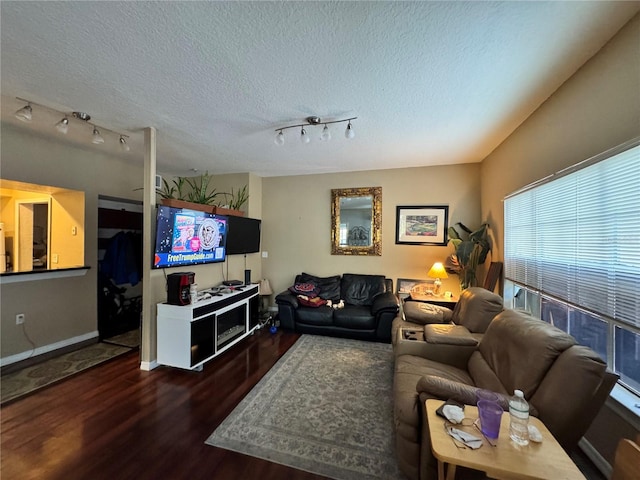 living room featuring rail lighting, a textured ceiling, and dark hardwood / wood-style flooring