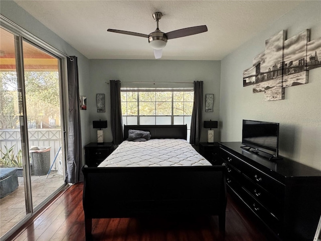 bedroom featuring multiple windows, access to exterior, dark hardwood / wood-style floors, and a textured ceiling