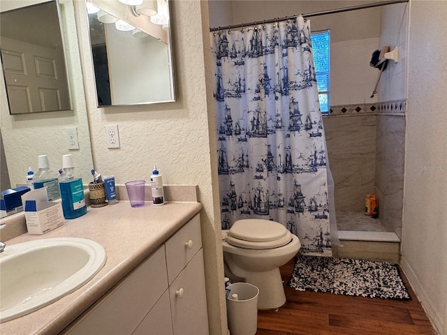 bathroom with hardwood / wood-style flooring, toilet, vanity, and a shower with curtain