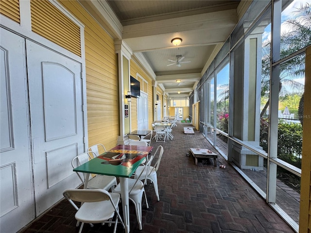 2328 Midtown Ter Unit 1024, Orlando, FL 32839 - sunroom / solarium with brick floors, outdoor dining area, ceiling fan, and wood walls