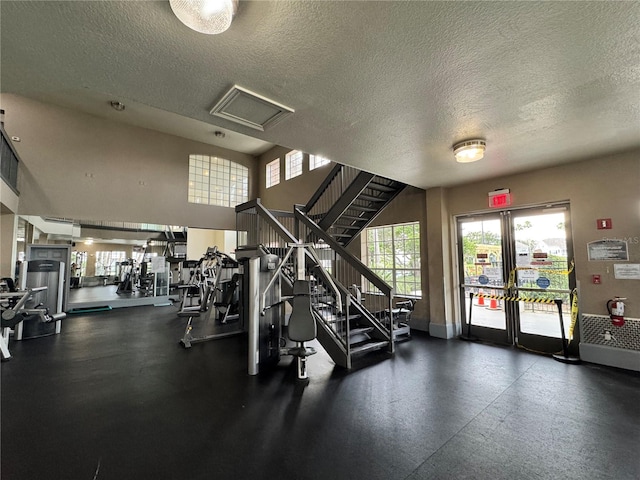 2328 Midtown Ter Unit 1024, Orlando, FL 32839 - gym featuring healthy amount of natural light, a textured ceiling, and french doors