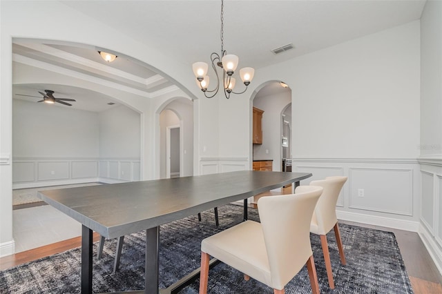 dining area featuring ceiling fan with notable chandelier and dark hardwood / wood-style floors