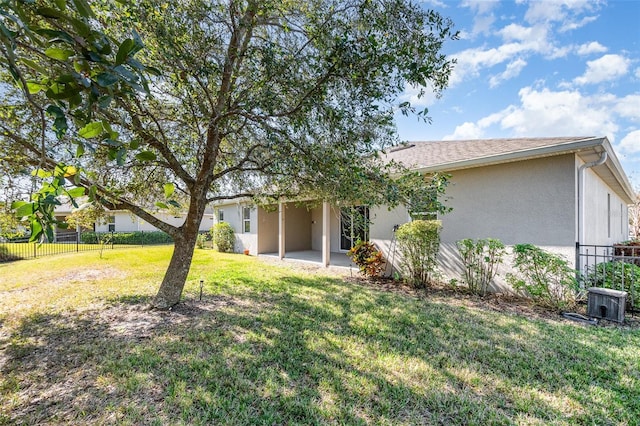 rear view of property with a yard, a patio, and central air condition unit