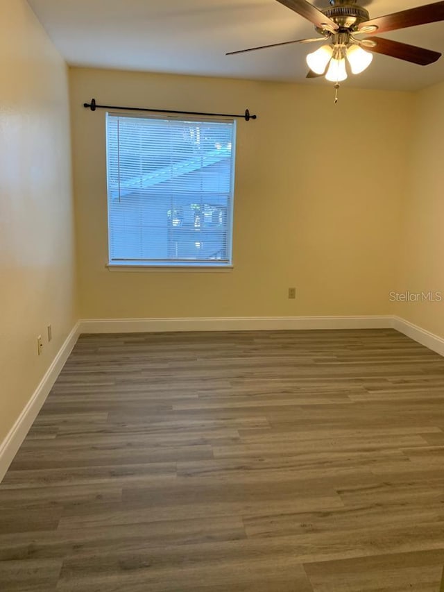 empty room featuring ceiling fan and dark hardwood / wood-style floors