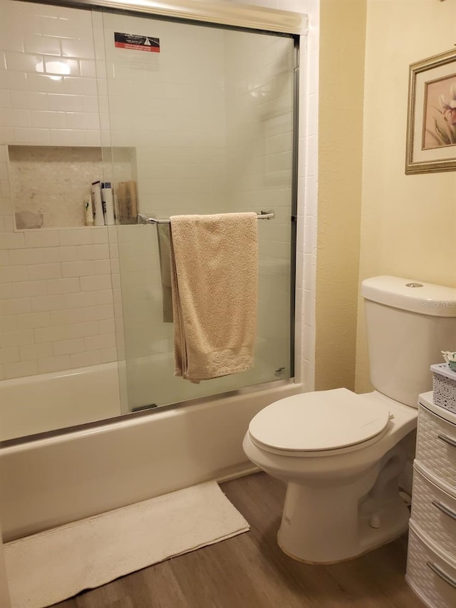 full bathroom with vanity, wood-type flooring, enclosed tub / shower combo, and toilet