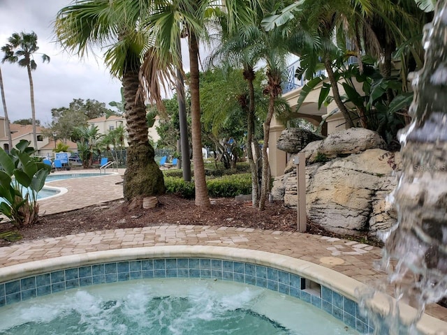 view of pool with a hot tub