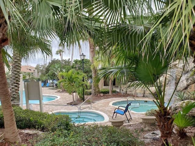 view of swimming pool with a community hot tub