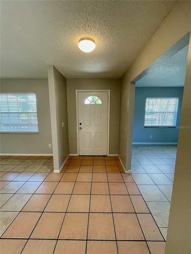 tiled foyer with a wealth of natural light and a textured ceiling