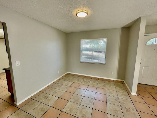 tiled foyer with a textured ceiling