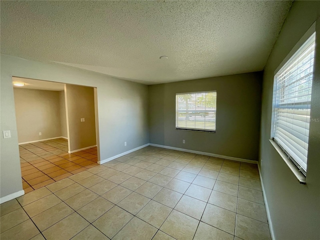 tiled empty room with a textured ceiling