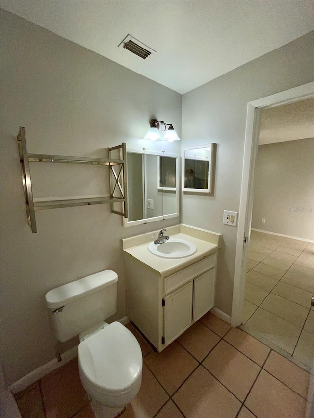 bathroom featuring vanity, tile patterned flooring, and toilet