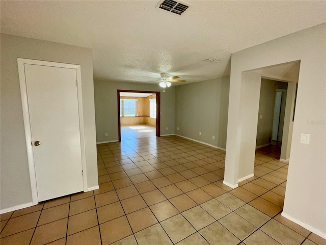 tiled spare room featuring a textured ceiling and ceiling fan