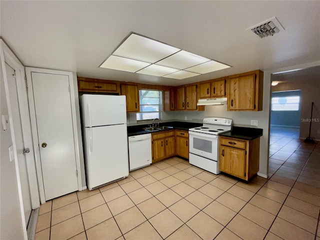 kitchen featuring white appliances, sink, and light tile patterned floors